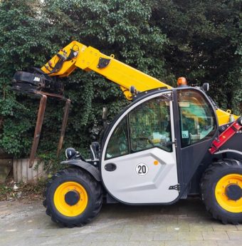 small-yellow-wheeled-forklift-standing-against-background-greenery_389554-1150